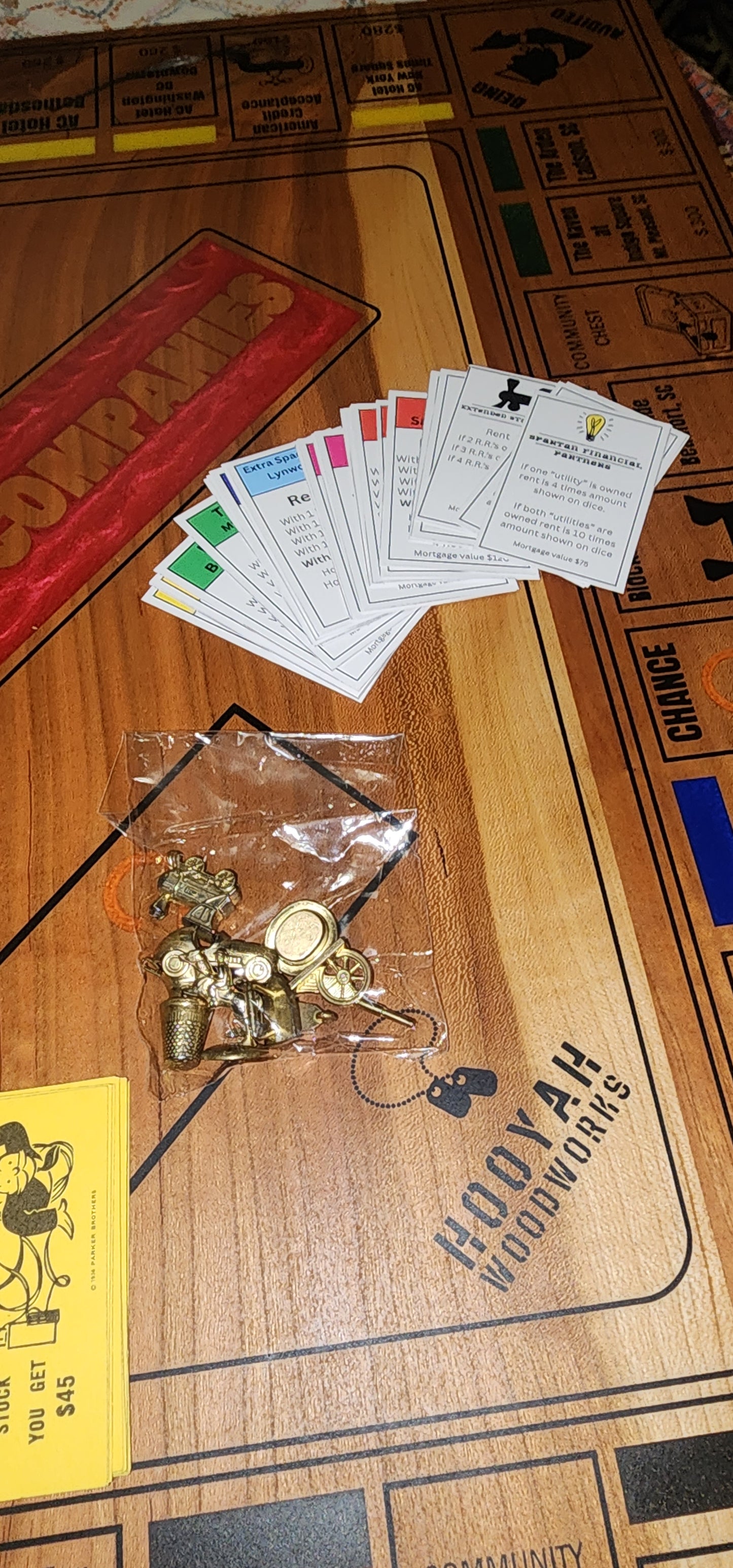 Wooden board game with cards and small gold figurines on a wooden surface