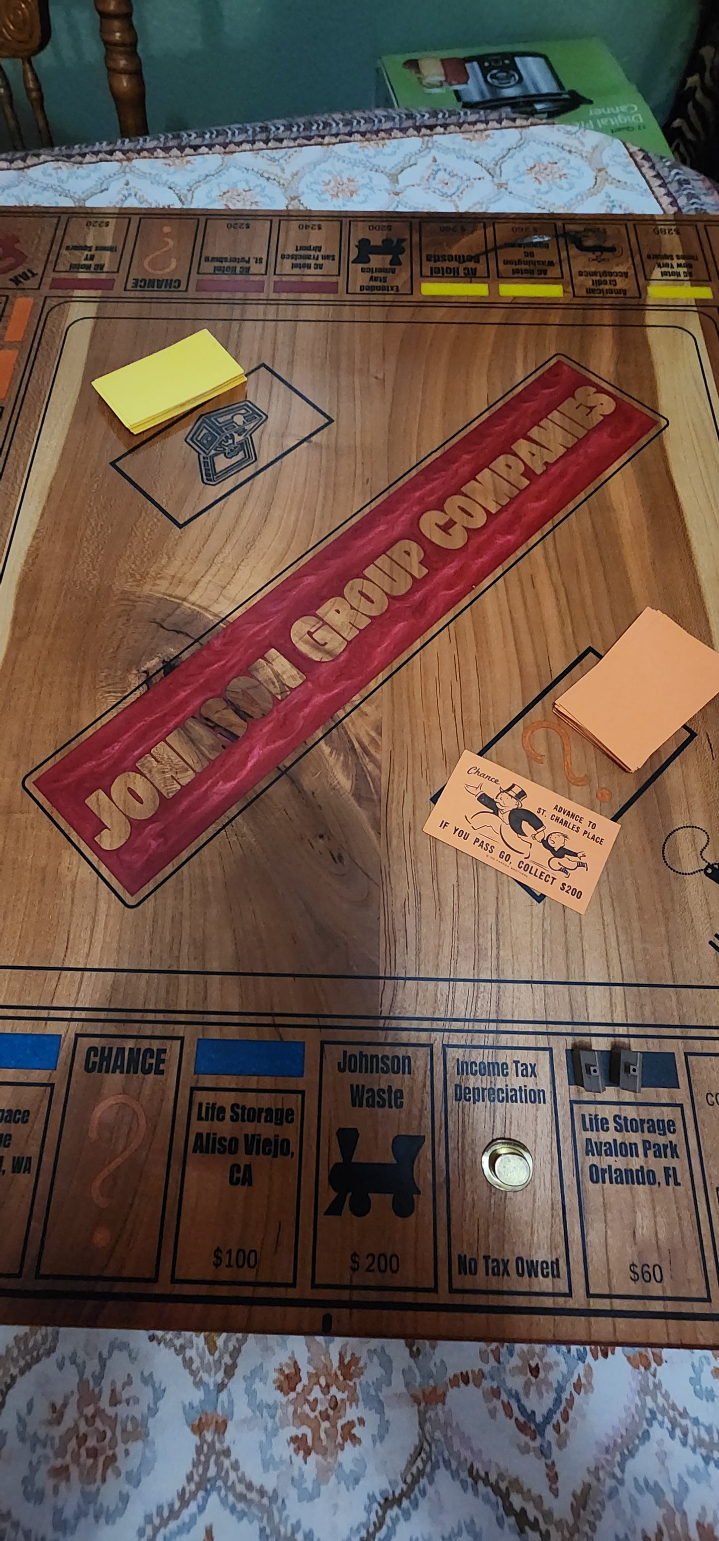 Close-up of a wooden Monopoly game board with various pieces and cards.