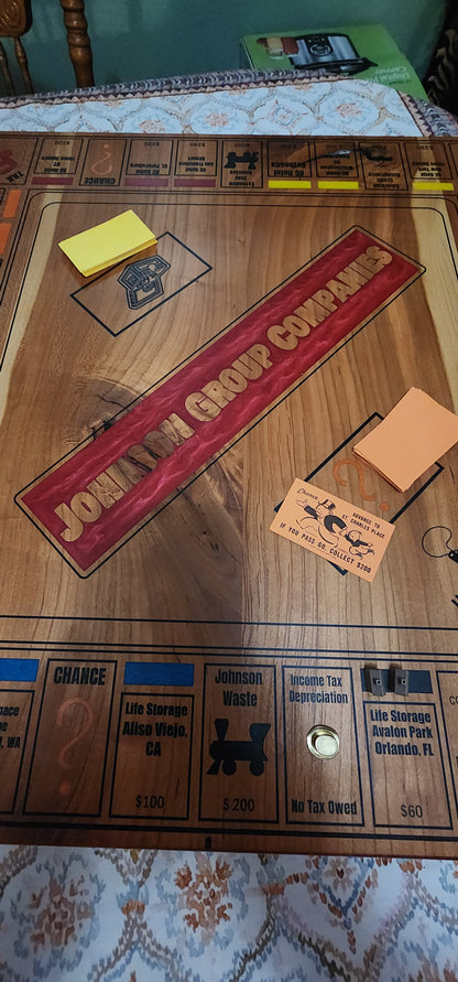 Close-up of a wooden Monopoly game board with various pieces and cards.