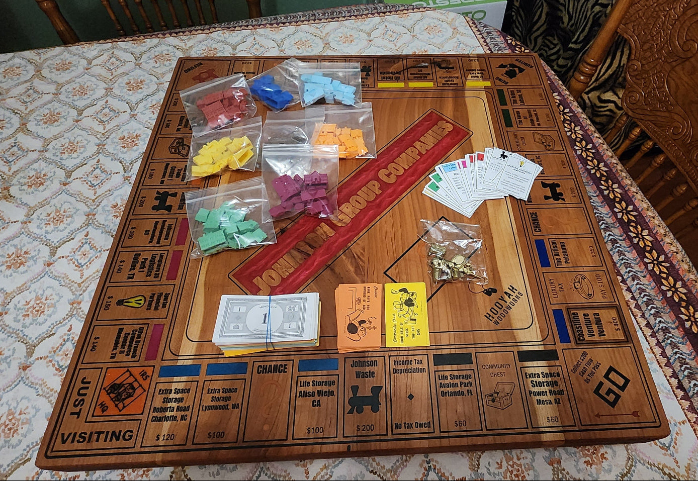 Wooden board game with pieces and cards on a patterned tablecloth