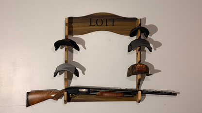 Wooden gun rack with hats and a rifle on a plain background