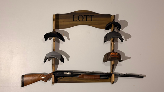 Wooden gun rack with hats and a rifle on a plain background