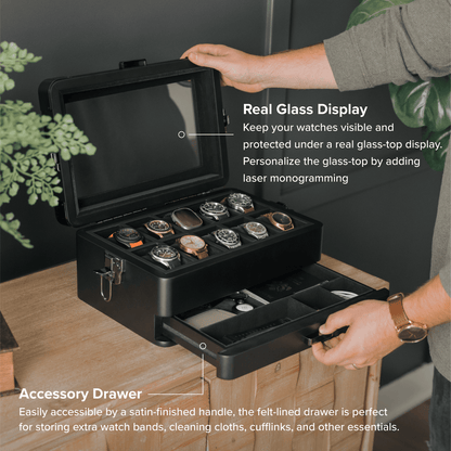 Black watch storage case with glass display and accessory drawer, held by a person.
