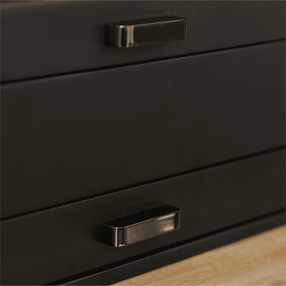 Close-up of a black metal drawer with a handle on a wooden surface.