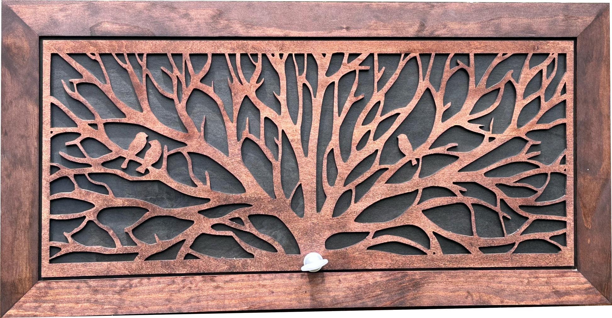Decorative metal grille with tree design and wooden frame