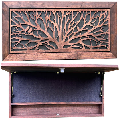 Wooden cabinet with decorative tree design on the door, open to reveal a dark interior.