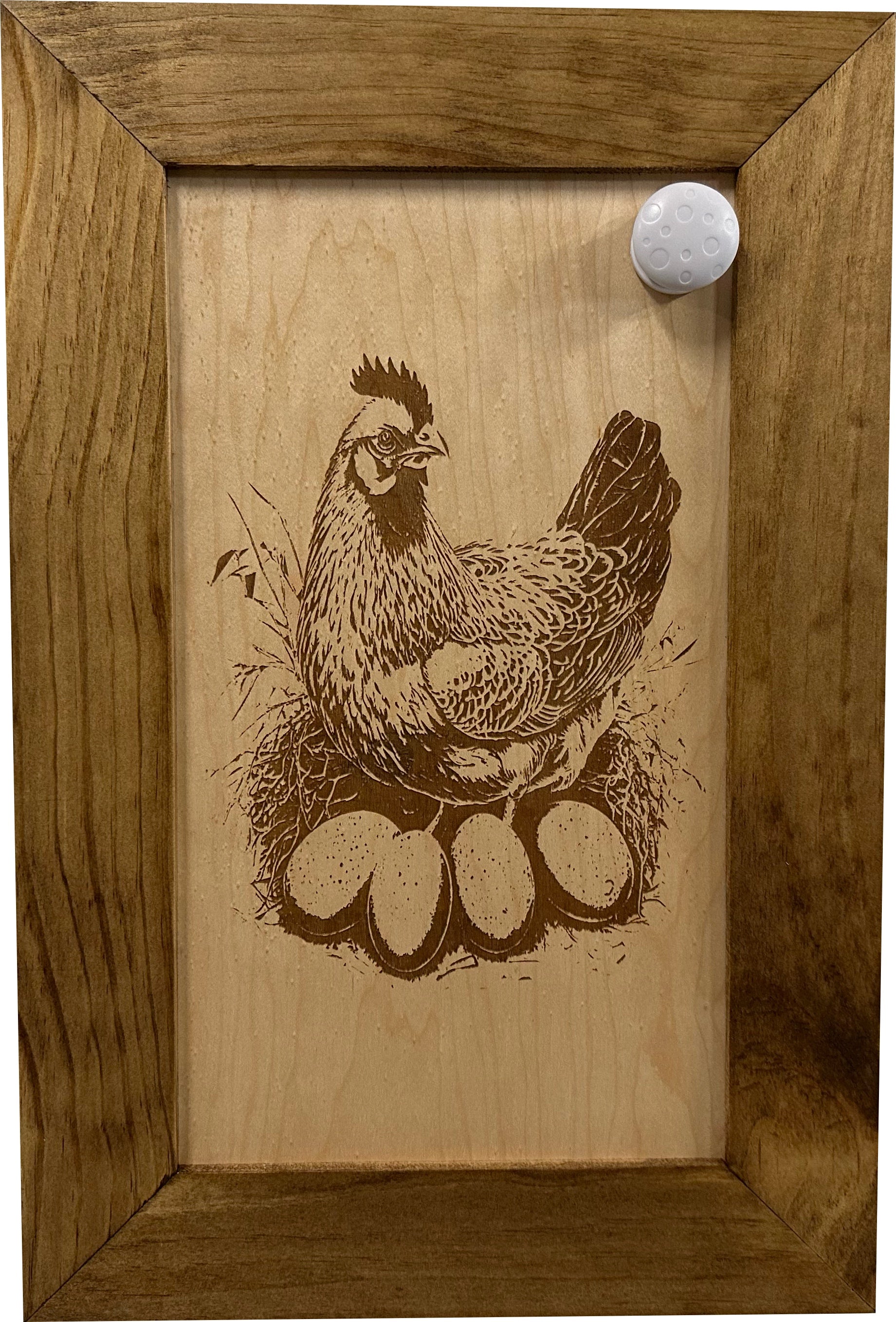 Wooden plaque with a chicken and eggs engraving in a wooden frame.
