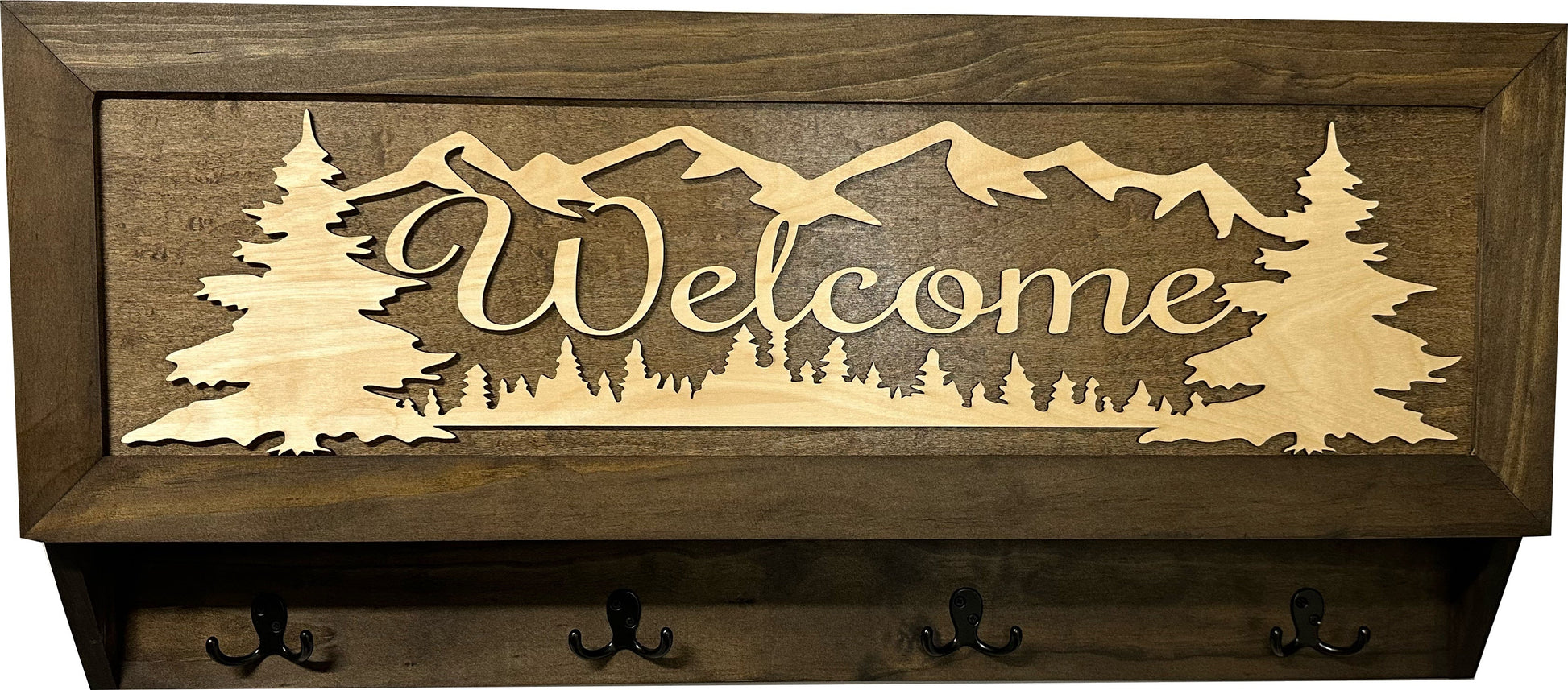 Wooden wall art with 'Welcome' and mountain design, featuring hooks on a wooden background.