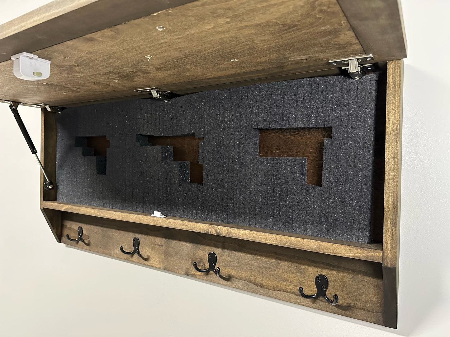 Wooden wall-mounted coat rack with hooks on a white background