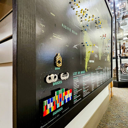 Display board with military rank insignia, badges, and a map of the Pacific Ocean.