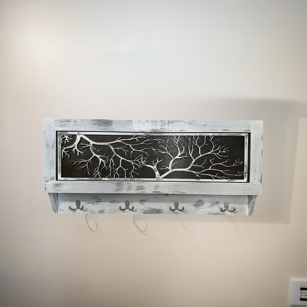 Wall-mounted shelf with decorative metal panel and hooks against a beige wall.