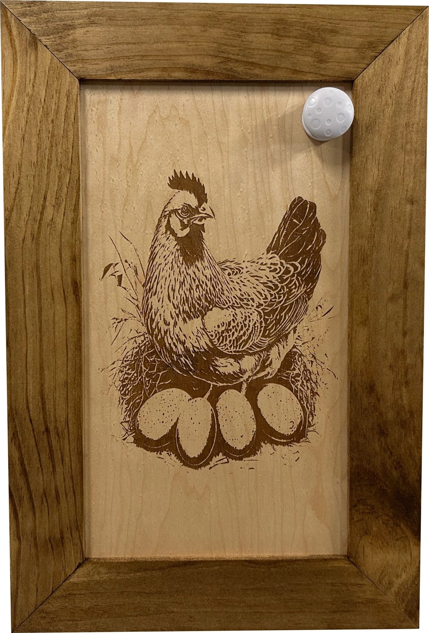 Wooden plaque with a chicken and eggs engraving in a wooden frame.