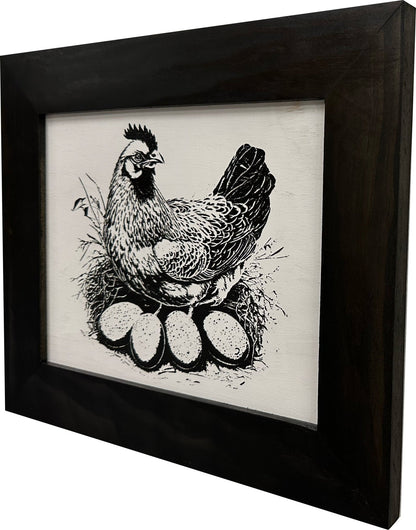 Framed artwork of a chicken with eggs on a white background